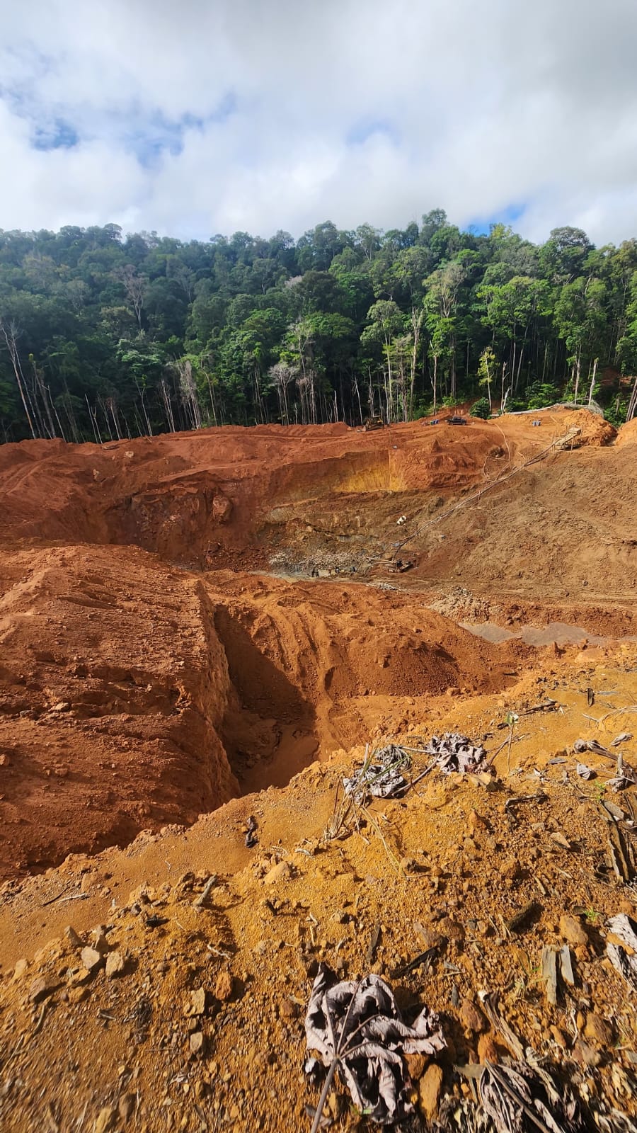 Open pit cut into red earth at the mining site